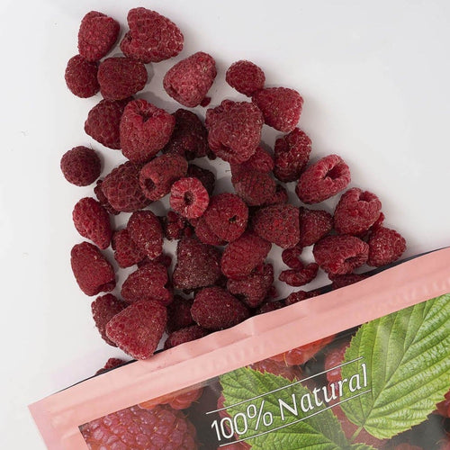raspberries spilled from a pink bag labeled '100% Natural' and 'raspberries' on a white background.